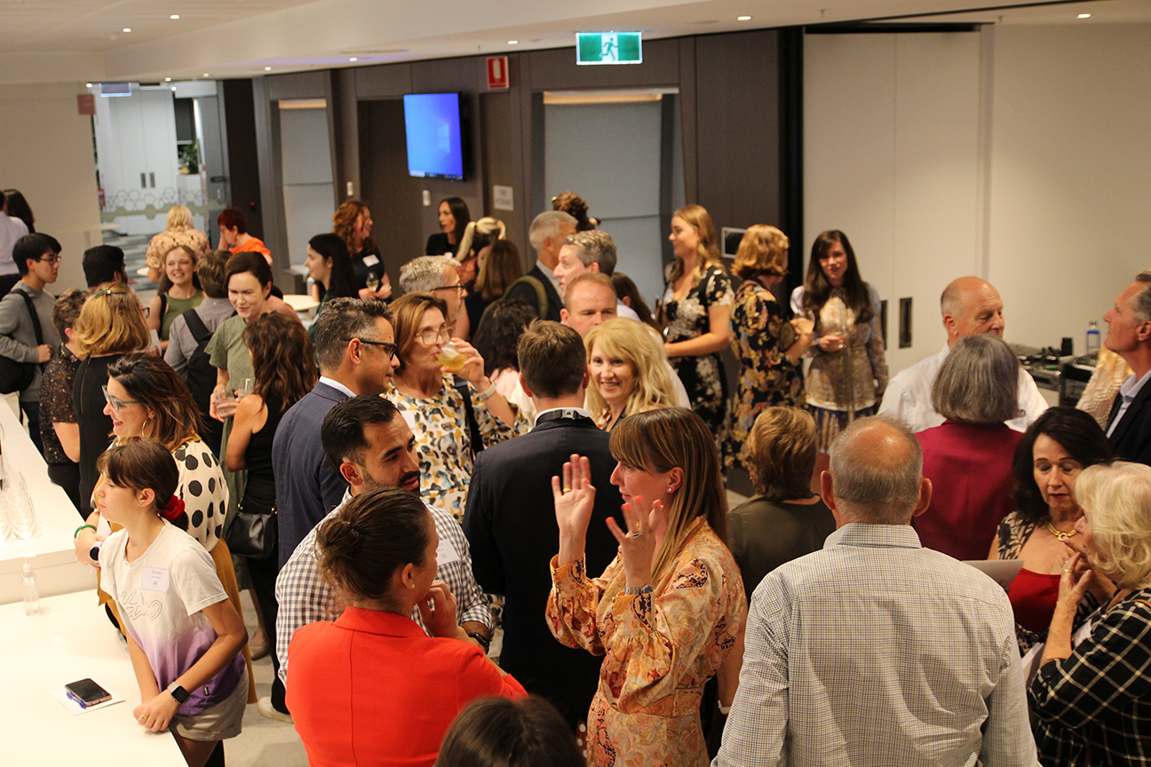 Some of the Pitchfest audience standing together chatting.